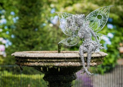 Fairy ornament sitting on a small water fountain