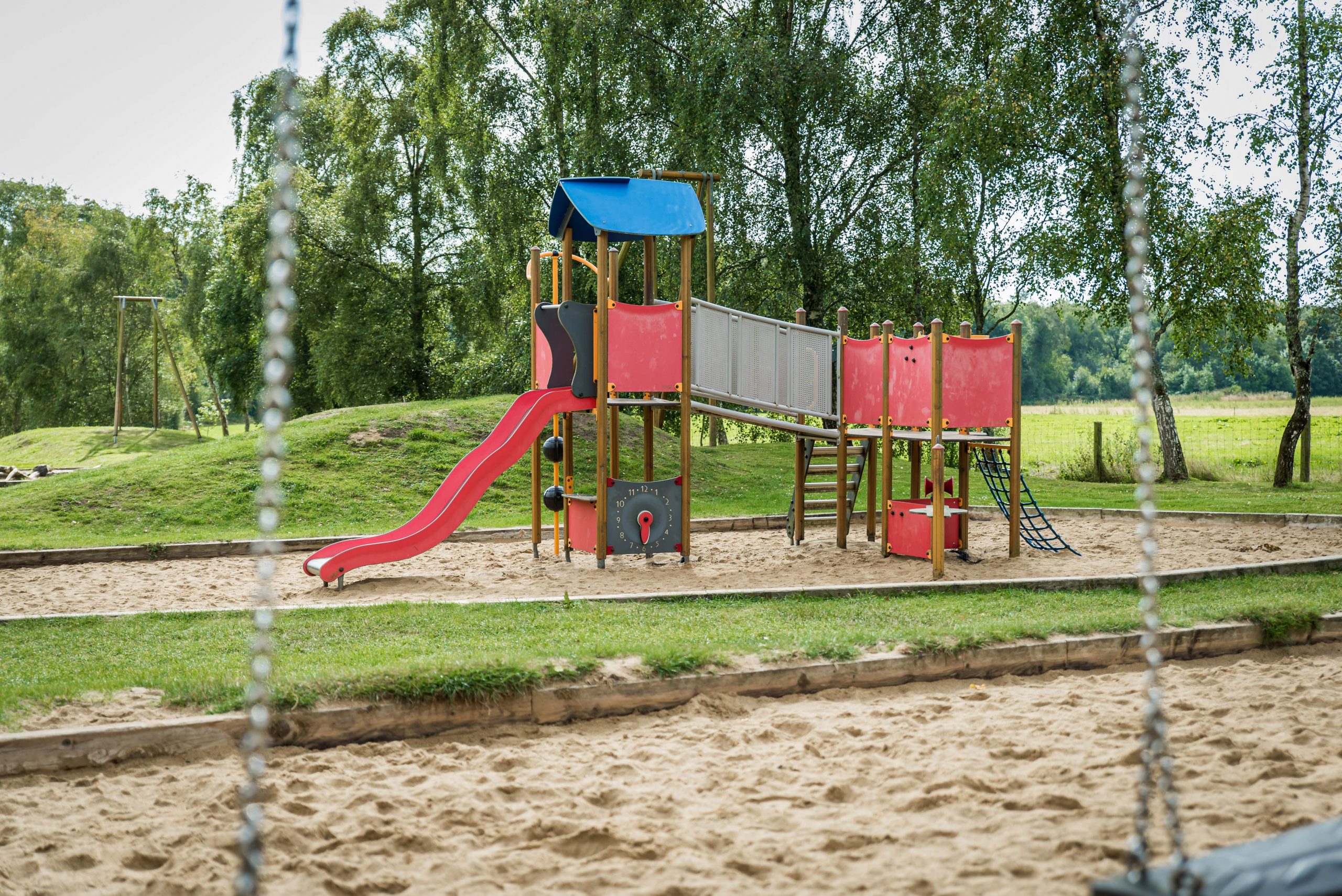 Outdoor playground set with slide, jungle gym, stairs and bridge