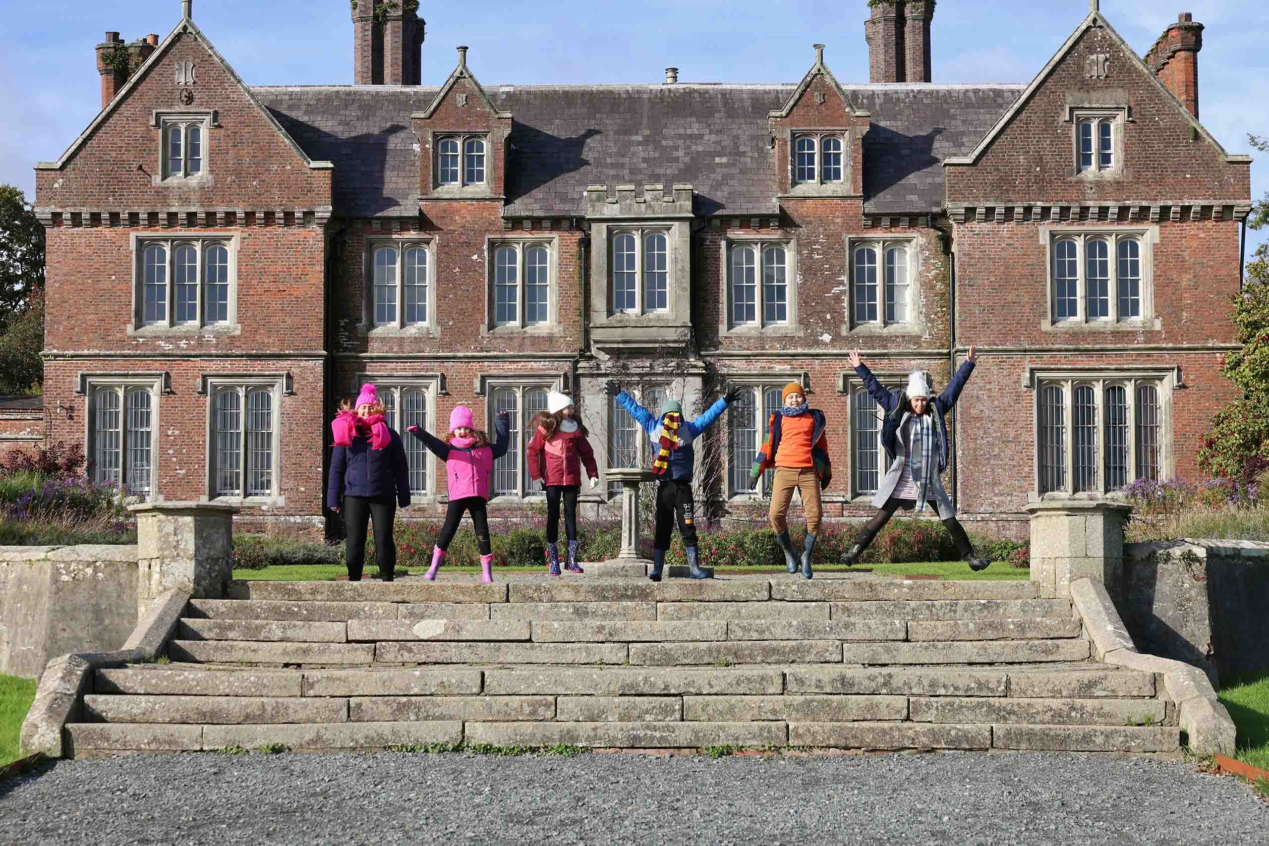 children jumping in the air on the steps at Wells House